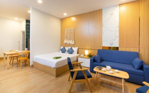Habitación de hotel con cama y sofá azul en Vy's House Phanthiet Hotel, en Ấp Tân An (1)