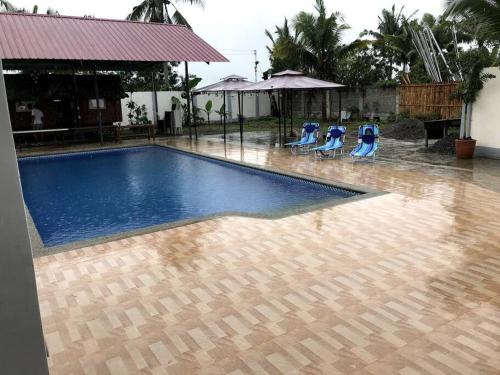 uma piscina com espreguiçadeiras azuis na chuva em Rainiers Private Resort House with 2 rooms 