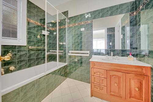a green tiled bathroom with a sink and a shower at 406 Back Porepunkah Road, Bright in Bright