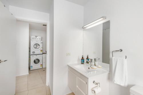 La salle de bains est pourvue d'un lavabo et d'un lave-linge. dans l'établissement Bellerive Quay - 2 Bedroom Apartment - Free Parking - Free WIFI, à Bellerive