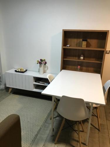 uma sala de jantar com uma mesa branca e cadeiras em Departamento 3 Personas em Chillán