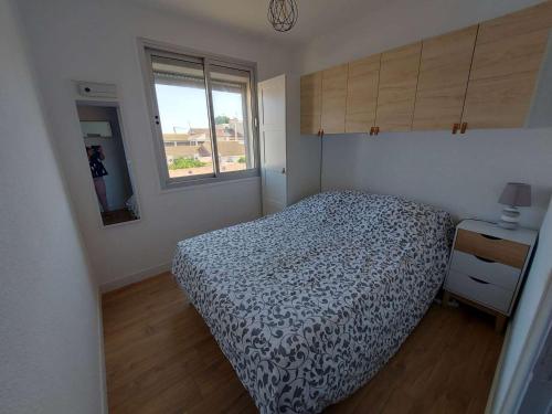 une petite chambre avec un lit et une fenêtre dans l'établissement Grau d'Agde: Appt 2P rénové à 20m de la plage - FR-1-423-282, au Grau-dʼAgde