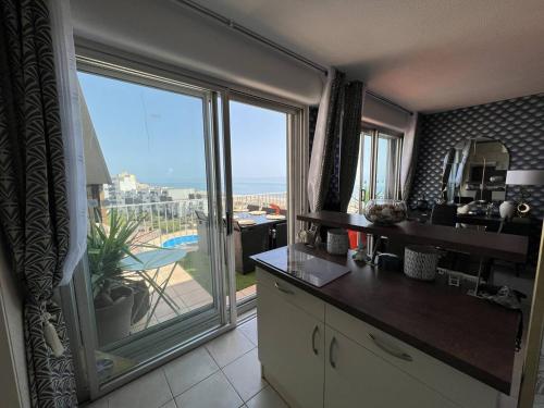 une cuisine avec une grande fenêtre donnant sur l'océan dans l'établissement T3 avec Terrasse et Vue Mer, Parking, Wi-Fi - 6 Personnes - FR-1-81-590, au Barcarès