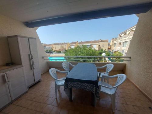 un balcon avec une table et des chaises sur un balcon dans l'établissement Appartement T2 avec Terrasse, Piscine et Parking Privé - 4 Pers. - FR-1-326-792, à Marseillan