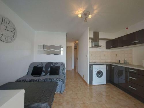 une cuisine et un salon avec un lit et une machine à laver dans l'établissement Appartement T2 avec Terrasse, Piscine et Parking Privé - 4 Pers. - FR-1-326-792, à Marseillan