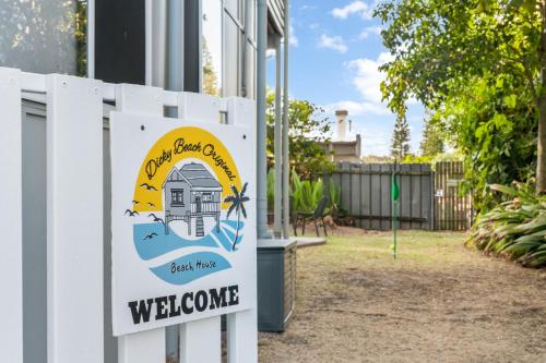 a welcome sign for a beach cottage on a fence at Dicky Beach Original - 2 Bed Downstairs Studio 200m to Beach in Caloundra