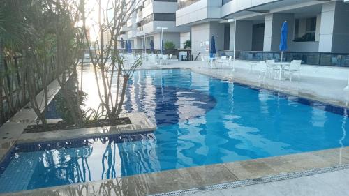uma piscina com água azul num edifício em Apartamento Estilo Prime em Salvador