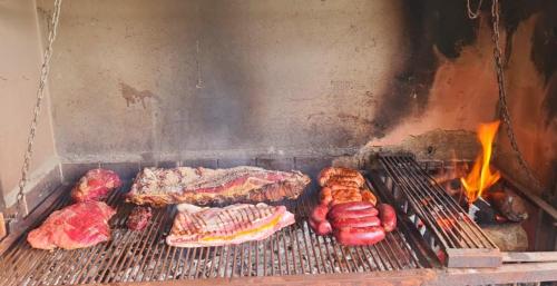 una parrilla con carne y otros alimentos. en imanalla en Salta
