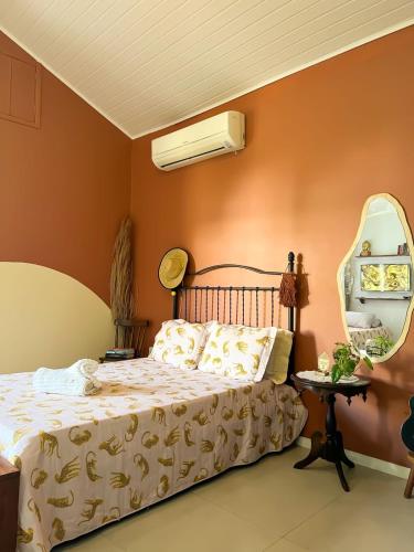 a bedroom with a bed and a mirror at Casa das Lunas in Praia do Forte