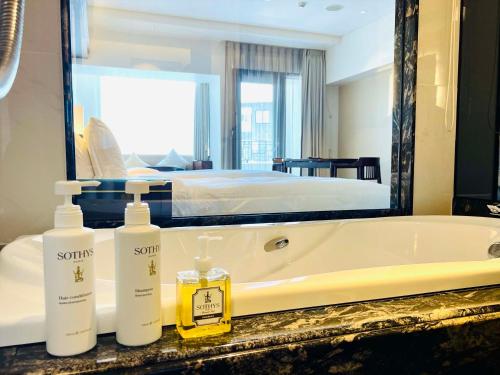 a bathroom with two bottles of soap and a bath tub at Okinawa EXES Naha in Naha