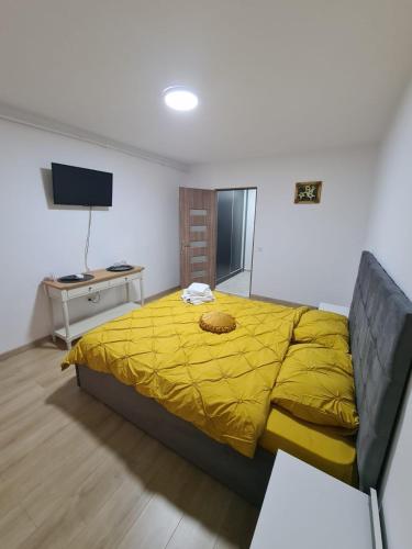 ピテシュティにあるGarsoniera Luxury Kevinのベッドルーム(黄色いベッド1台、デスク付)