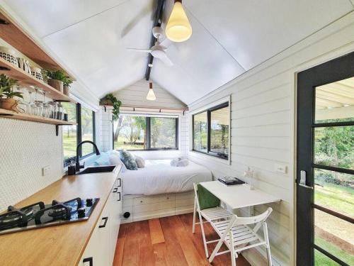 una cocina con una cama en una casa pequeña en Mornington Peninsula Tiny House - Tiny Stays, en Red Hill