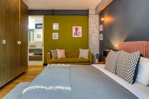 a bedroom with a large bed and a couch at Unique Roma Apartments S51 By MrW in Mexico City