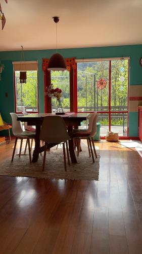 a dining room with a wooden table and chairs at Casa Río Calle Calle in Valdivia