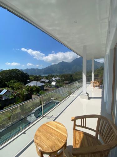 a balcony with a table and chairs and a view at Batur Pyramid Guesthouse in Kintamani