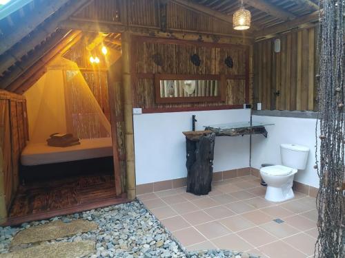 ein Badezimmer mit einem WC in einer Holzkonstruktion in der Unterkunft Alojamiento Natural La Cueva de Morgan San Rafael in San Rafael