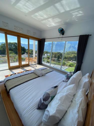 a large bed in a room with a large window at Batur Pyramid Guesthouse in Kintamani