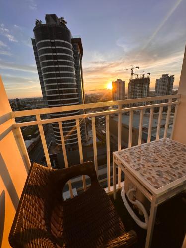 a table and chair on a balcony with a sunset at Lengs Place 2 - Studio Unit with Balcony at Inspiria Condo in Davao City