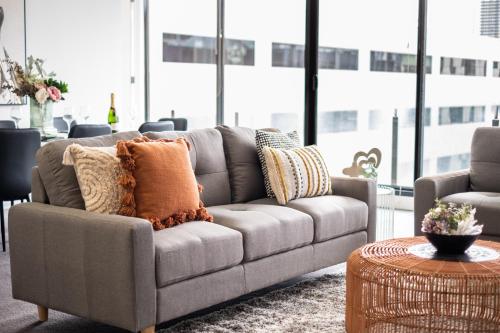 una sala de estar con un sofá y una mesa en Mega Style Apartments Capri, en Melbourne
