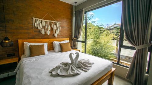- une chambre avec un lit et une grande fenêtre dans l'établissement Villa Olive, à Dalung