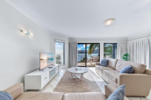 エアリービーチにあるWhitsunday Beachfront Apartment on Broadwaterのソファとテレビのあるリビングルーム