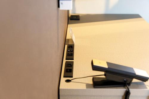 an office desk with a printer with a charger at HOTEL Third Place Hakata in Fukuoka
