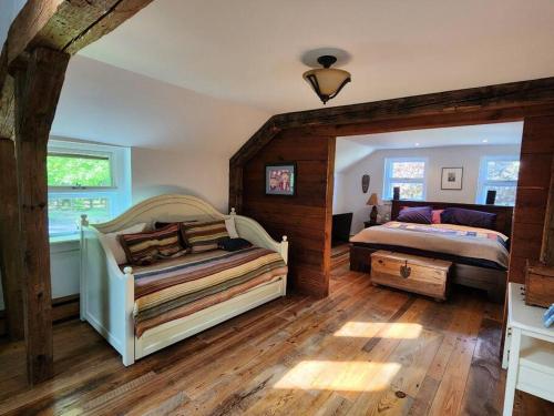 um quarto com 2 camas num quarto com pisos em madeira em Summer Rental Magical Converted Barn & Pool House em Pleasant Valley