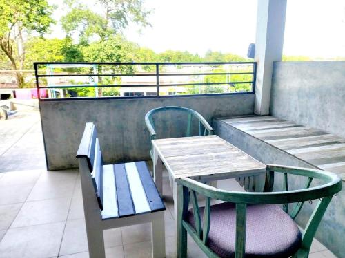 a bench and a table and a chair on a balcony at Baan Minnie 2 bedroom home 400m from Saikaew beach in Ko Samed