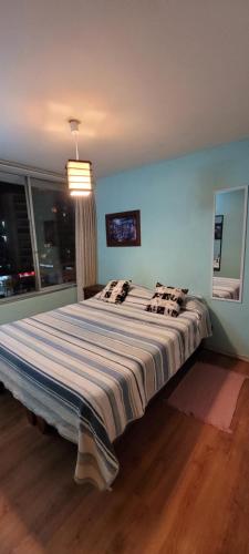uma cama grande num quarto com uma parede azul em Departamento viña centro em Viña del Mar