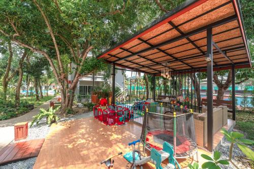 an outdoor play area with a playground in a park at The One Cozy Vacation Residence SHA Hotel in Chalong 