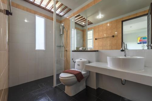 La salle de bains est pourvue de toilettes, d'un lavabo et d'une douche. dans l'établissement The One Cozy Vacation Residence SHA Hotel, à Chalong