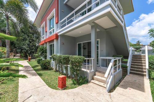 a house with a staircase leading to the front door at The One Cozy Vacation Residence SHA Hotel in Chalong 