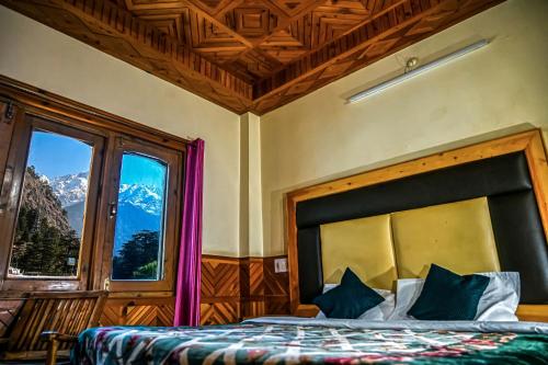 a bedroom with a bed with a view of a mountain at Diya Palace Kasol in Kasol