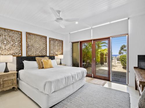 a bedroom with a bed and a sliding glass door at Liapari Beach House in Sapphire Beach