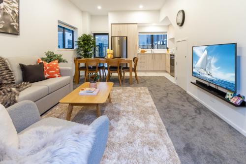 a living room with a couch and a table at 3 Bedroom 2 Bathroom Hagley Parkside Perch in Christchurch