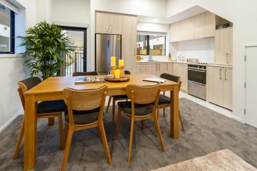 a kitchen with a wooden dining room table and chairs at 3 Bedroom 2 Bathroom Hagley Parkside Perch in Christchurch