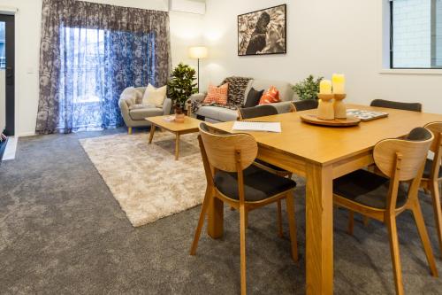 a living room with a wooden table and chairs at 3 Bedroom 2 Bathroom Hagley Parkside Perch in Christchurch