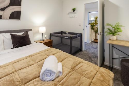 a bedroom with a bed with a towel on it at 3 Bedroom 2 Bathroom Hagley Parkside Perch in Christchurch