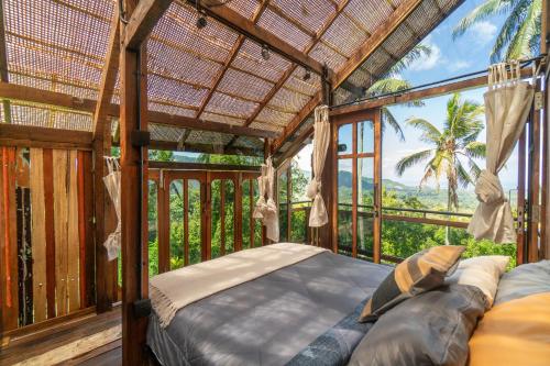 Silebeng的住宿－The Rampage House，一间卧室,在阳台上配有一张床,享有美景