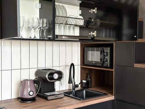 Una cocina con un fregadero y una cafetera en una encimera. en NEW Studio with Home Theater, en Bishkek