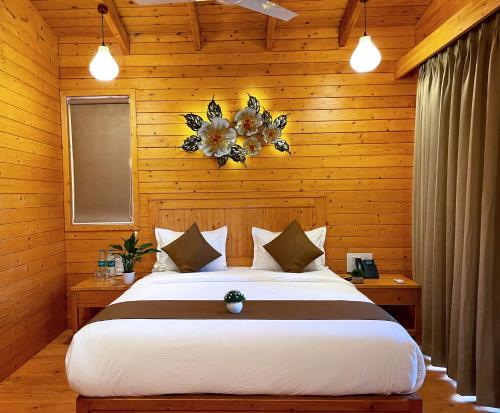 Villament Resort, Karjat في كارجات: غرفة نوم بسرير كبير وبجدار خشبي