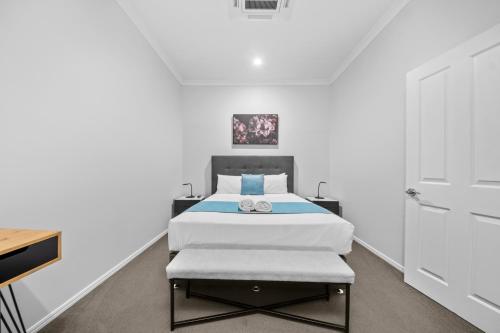 a bedroom with a bed and a white wall at CocoBrew Boutique Apartments in Rockhampton
