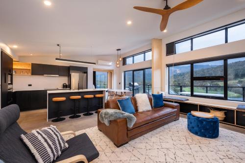 a living room with a couch and a kitchen at Black Diamond Crackenback in Crackenback