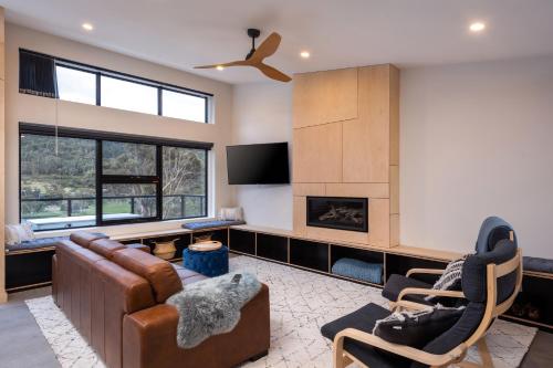 a living room with a couch and chairs and a fireplace at Black Diamond Crackenback in Crackenback