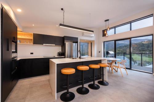 a kitchen with a counter and some stools at Black Diamond Crackenback in Crackenback