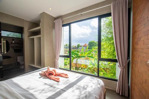 - une chambre avec un lit et une grande fenêtre dans l'établissement Villa Hazel, à Dalung