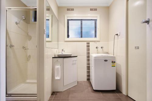 a bathroom with a sink and a toilet and a shower at Grevillea Gardens Unit 8 in Bright