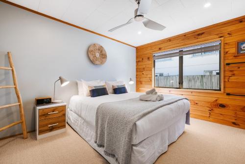 una camera con letto e finestra di The Iconic Kiwi Bach, Full Site Downtown Mount a Mount Maunganui