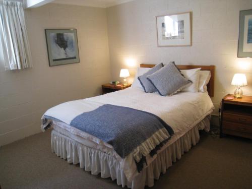 een slaapkamer met een groot bed met 2 tafels en 2 lampen bij Breakfast Provisions Provided With Harbour View in Howrah