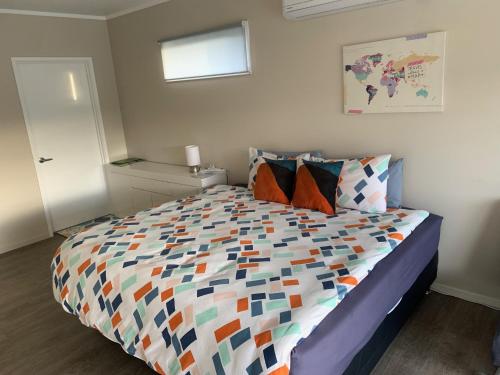 um quarto com uma cama com um edredão colorido em KG Studio em Palmerston North